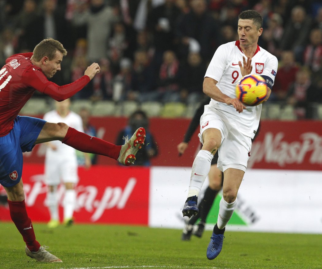 Robert Lewandowski se snaží zblokovat střelu Jakuba Jankto