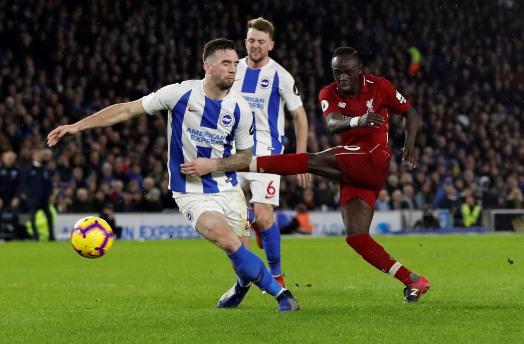 Liverpoolský Sadio Mané zakončuje přes bránícího Shanea Duffyho z Brightonu