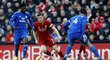 Liverpoolský James Milner prochází mezi dvojicí bránících hráčů Cardiffu