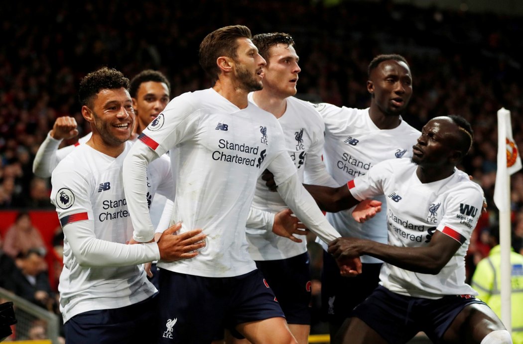 Fotbalisté Liverpoolu oslavují branku Adama Lallany, který vyrovnal zápas s Manchesterem United na konečných 1:1