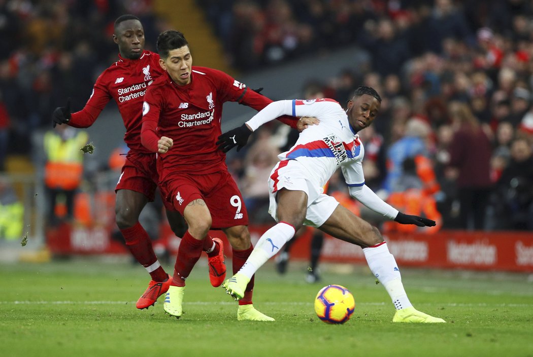 Aaron Wan-Bissaka se snaží odzbrojit dvojici z Liverpoolu Roberto Firmino, Naby Keita