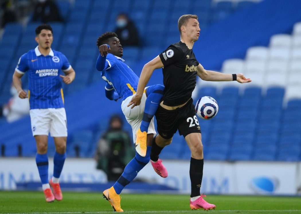 Tomáš Souček z West Hamu se dostává k míči v souboji s Yvesem Bissoumou z Brightonu