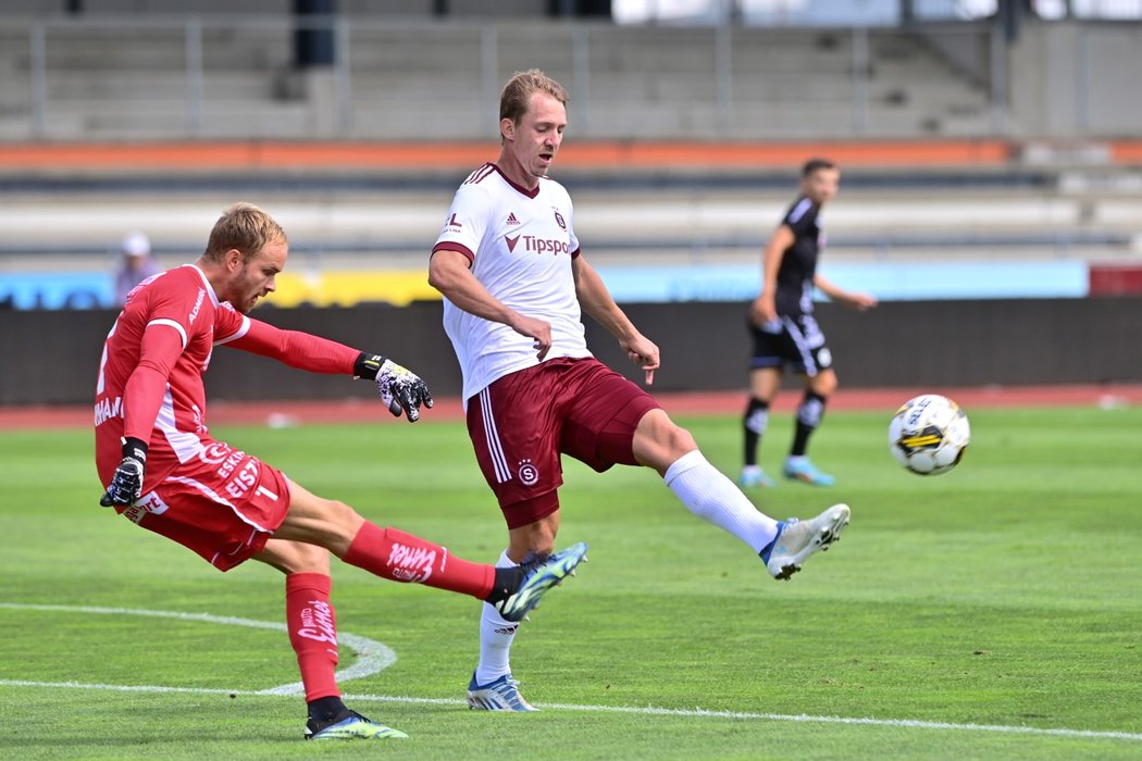 Gólman soupeře odkopává míč před Lukášem Julišem