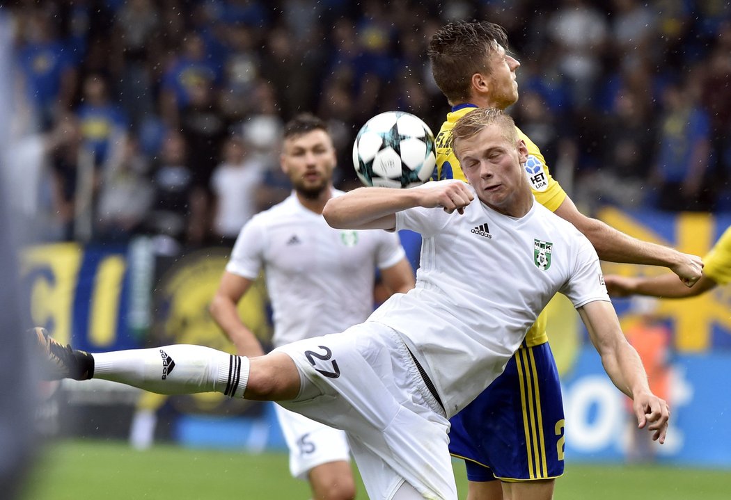 Filip Panák z Karviné bojuje o míč se zlínským obráncem Lukášem Bartošákem