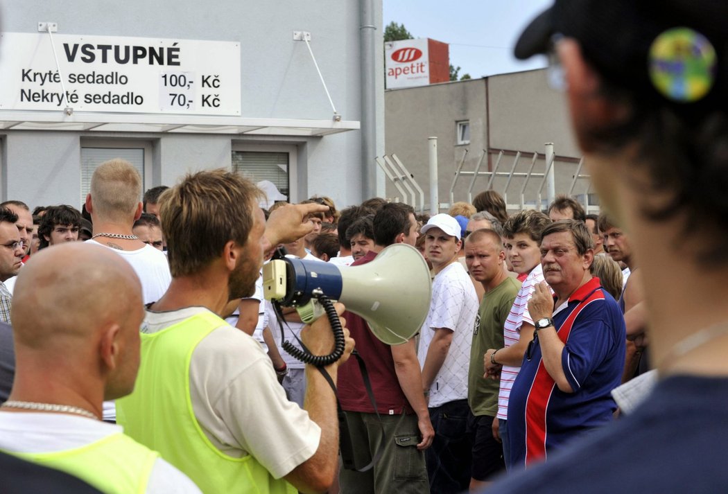 Pořadatel s megafonem se snaží uklidnit fanoušky Baníku před pokladnou olomouckého stadionu