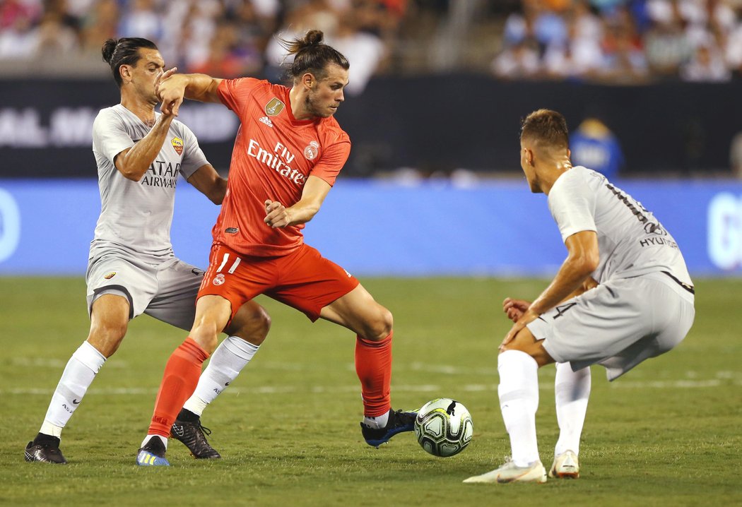 Gareth Bale se snaží proklestit si cestu k brance AS Řím přes Patrika Schicka.