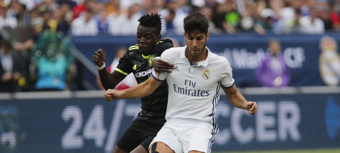 Marco Asensio z Realu drží míč před Babou Rahmanem z Chelsea