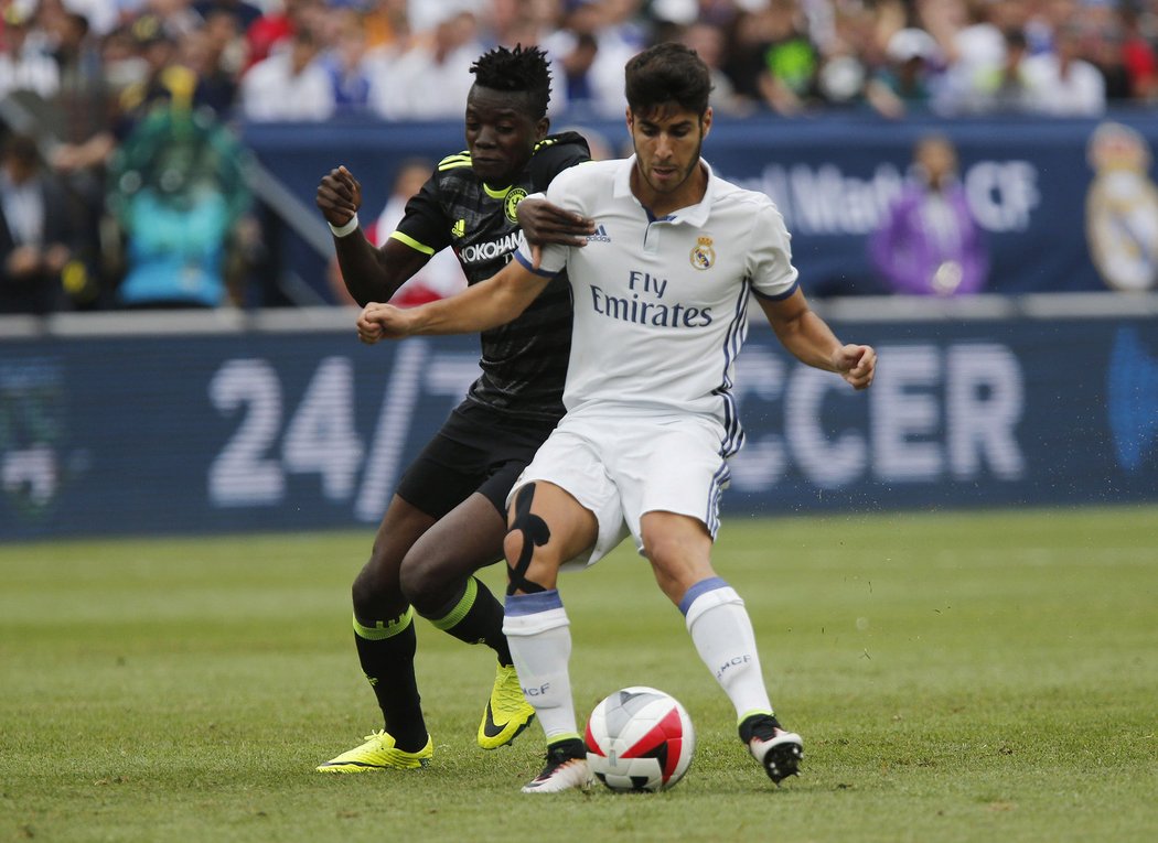 Marco Asensio z Realu drží míč před Babou Rahmanem z Chelsea