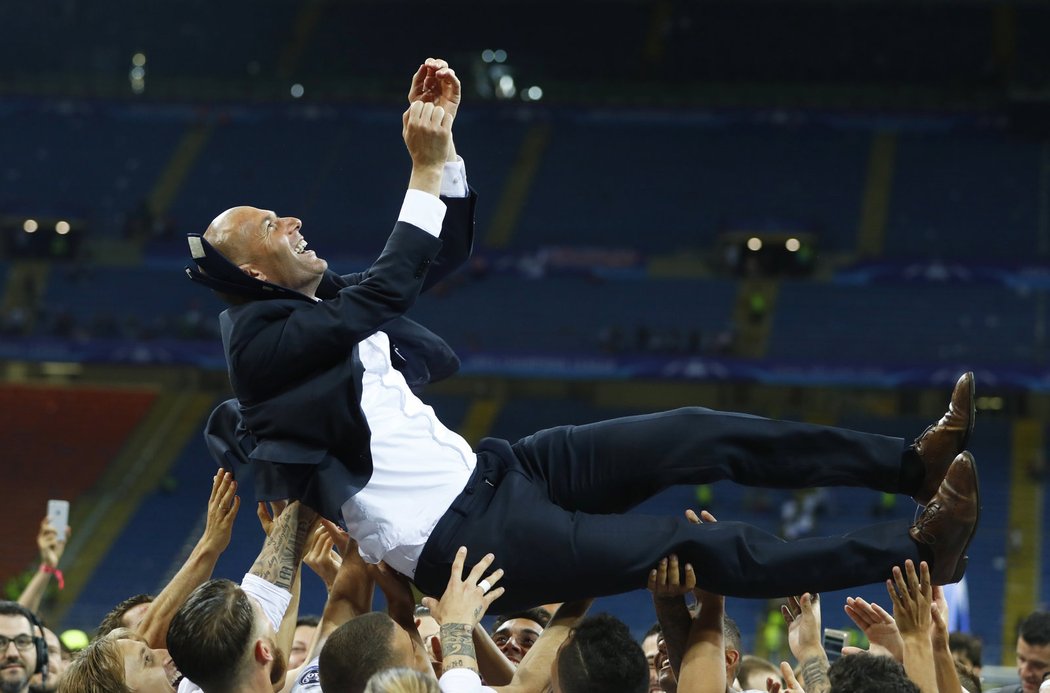 Trenér Realu Zinedine Zidane nad hlavami hráčů po výhře ve finále Ligy mistrů