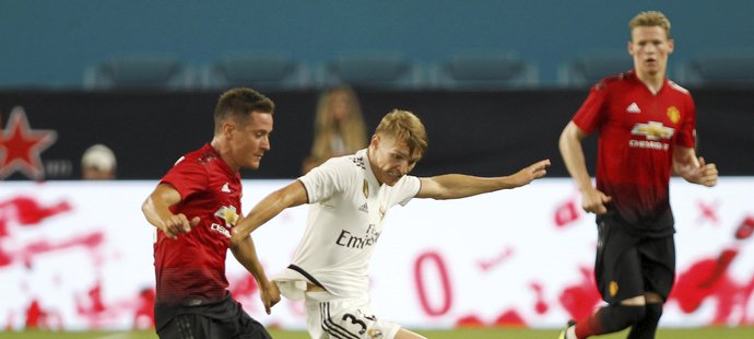 Martin Ödegaard v souboji s Anderem Herrerou z Manchesteru United.