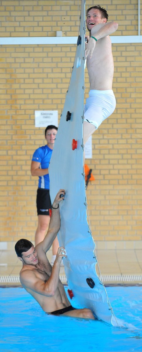 Tomáš Vaclík (vpravo) a Ondřej Čelůstka se snaží v bazénu dostat na lezeckou stěnu