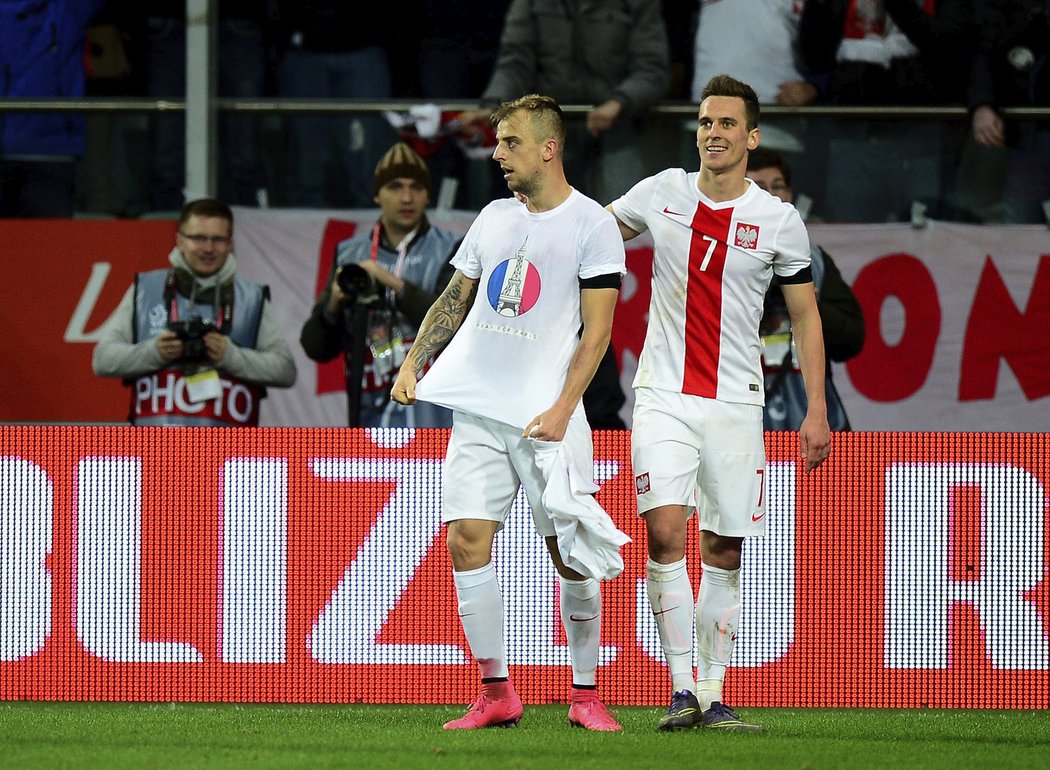 Polská radost po druhé brance do české sítě. Střelec Kamil Grosicki sundal dres a na triku měl obrázek vyjadřující podporu obětem teroristického útoku z Paříže