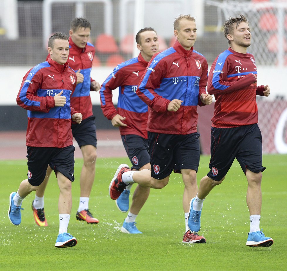 Dva nováčci ve fotbalové reprezentaci Jan Sýkora (vlevo) a Lukáš Pokorný (druhý zprava) si první trénink užívali i v dešti