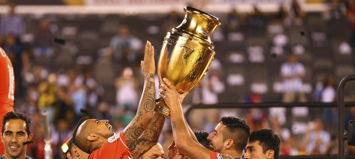 Arturo Vidal (8) a Mauricio Isla se radují s vítěznou trofejí