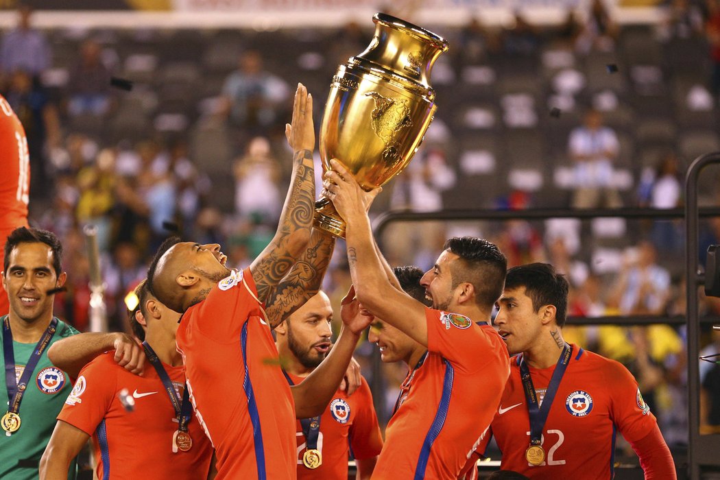 Arturo Vidal (8) a Mauricio Isla se radují s vítěznou trofejí