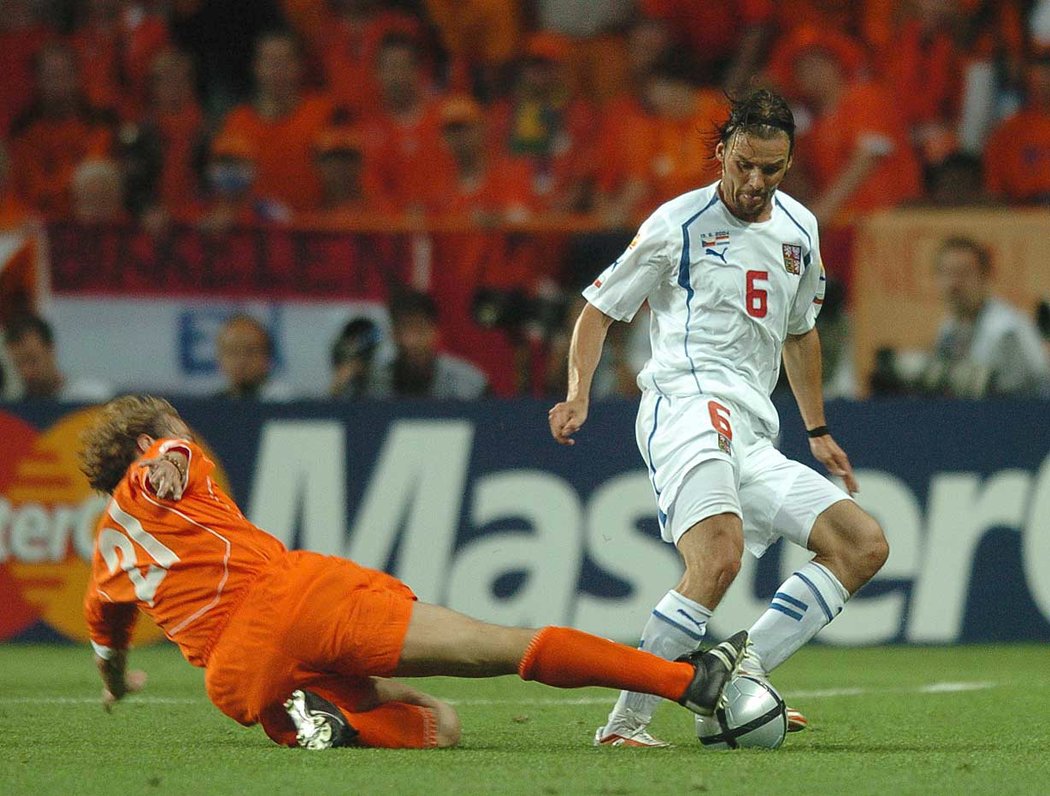 Nizozemec Paul Bosvelt se snaží obrat o míč Marka Jankulovskiho v duelu na EURO 2004
