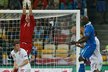 Anglický brankář Joe Hart zasahuje proti míči z italských kopaček, vpravo skáče Mario Balotelli