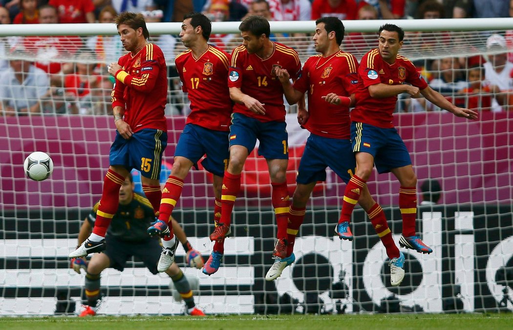 Španělé Sergio Ramos (zleva), Alvaro Arbeloa, Xabi Alonso, Sergio Busquets a Xavi Hernandez skáčí ve zdi při přímém kopu Andrea Pirla