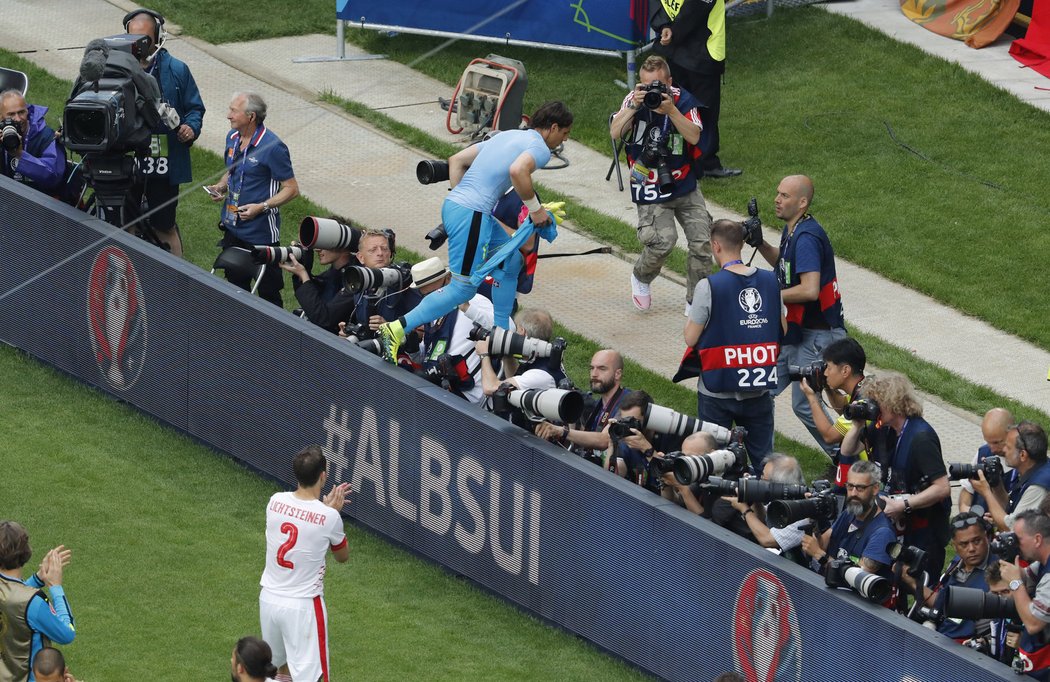 Švýcarský brankář Yann Sommer přeskakuje bariéru a jde se pozdravit s fanoušky po úvodní výhře na EURO proti Albánii