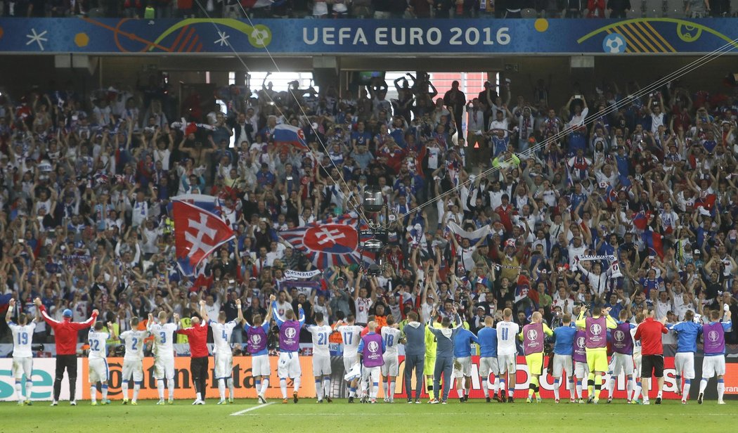 Slovenští fotbalisté se radují spolu z fanoušky z historicky prvního vítězství na EURO po triumfu nad Ruskem