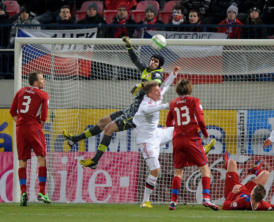 Nejistý Petr Čech ve vzdušném souboji. Z něj si podobně jako soupeř Andreas Cornelius odnesl bolestivé zranění