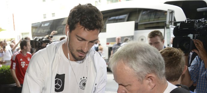 Obránce Mats Hummels se podepisuje jednomu ze sběratelů autogramů