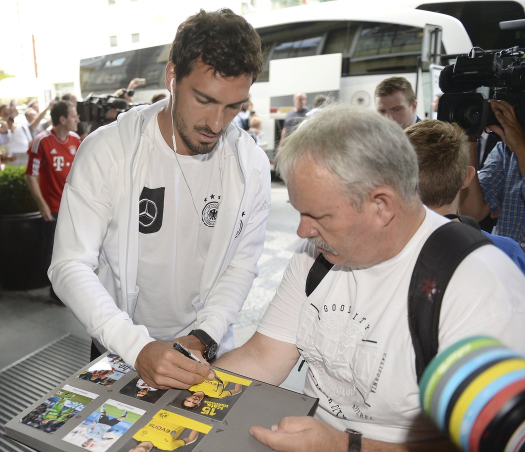 Obránce Mats Hummels se podepisuje jednomu ze sběratelů autogramů