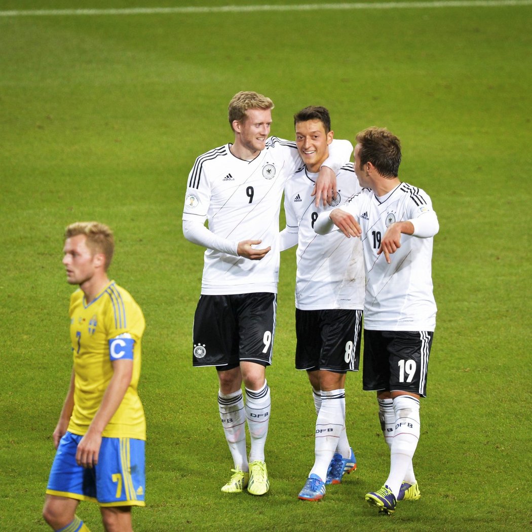 André Schürrle slaví s parťáky z německé reprezentace Mesutem Özilem a Mariem Götzem svůj gól Švédsku