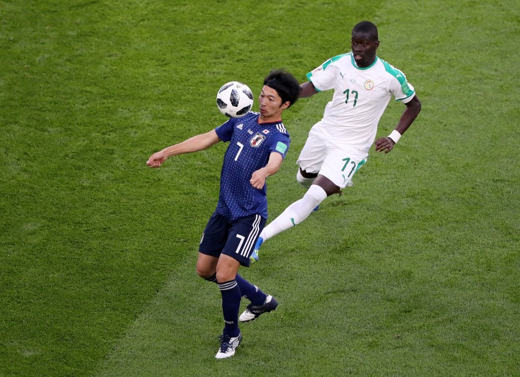 Senegalský záložník Badou Ndiaye stínuje při zpracování míče Gaka Šibasakiho z Japonska