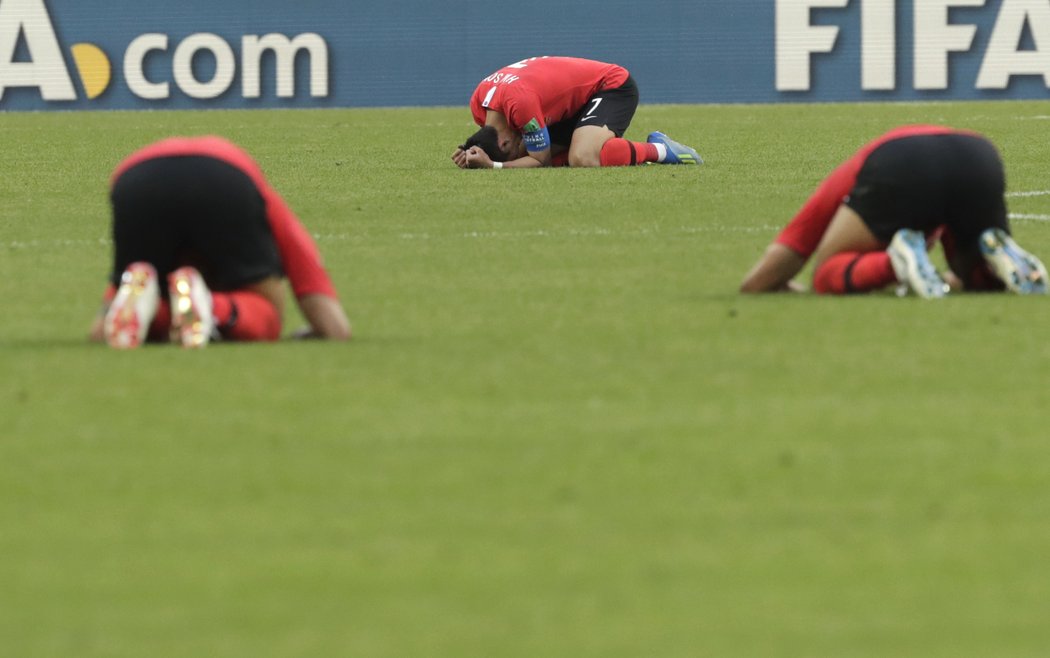 Jihokorejští fotbalisté klečí na trávníku poté, co jim triumf nad Německem nestačil k postupu do osmifinále MS