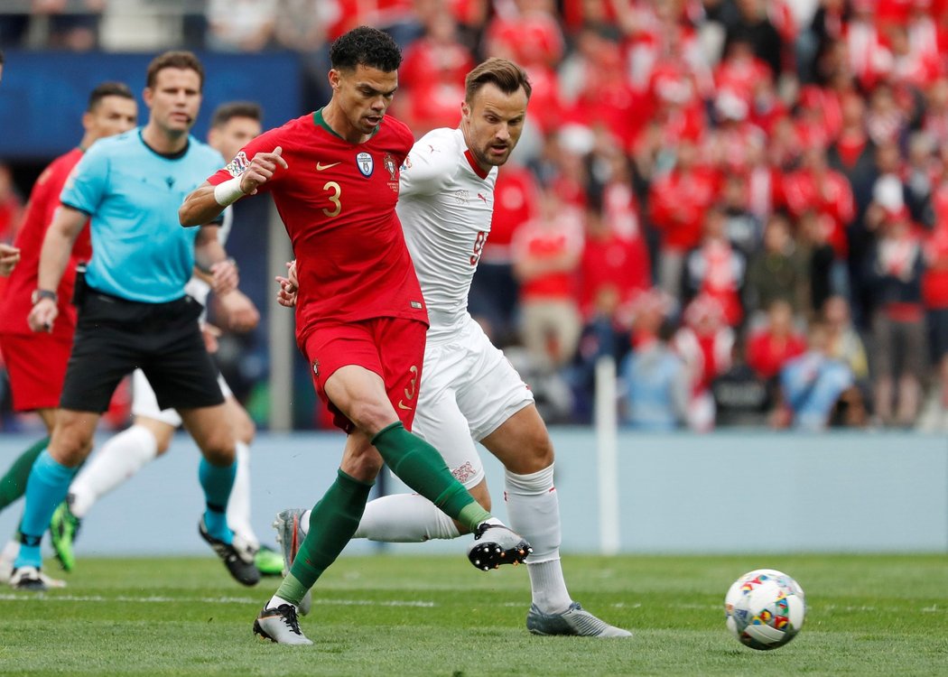 Portugalský stoper Pepe odehrává míč před presujícím útočníkem Harisem Seferovicem ze Švýcarska