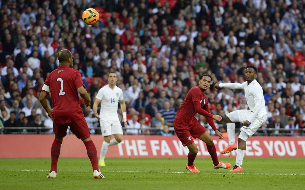 Daniel Sturridge (vpravo) sleduje míč, který míří za záda peruánského brankáře