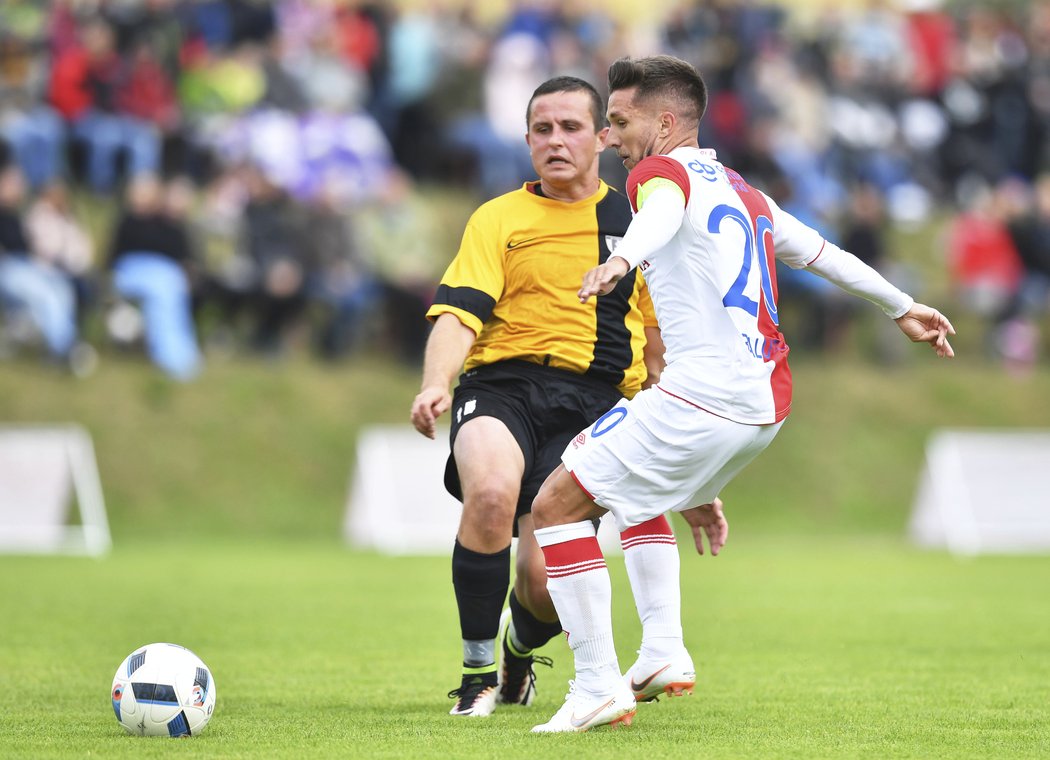 Rumunský záložník Alexandru Baluta v souboji s Martinem Odvářkou z  Chotěboře