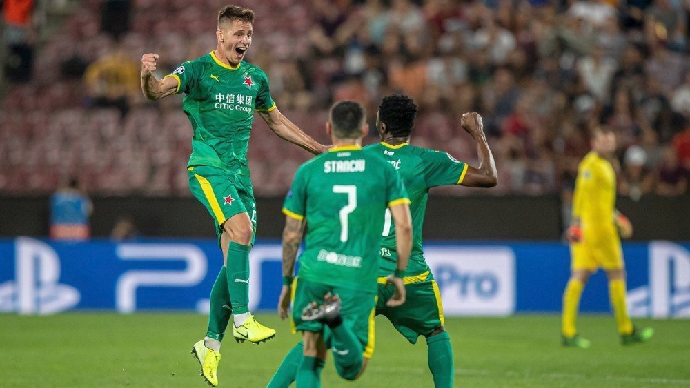 Lukáš Masopust oslavuje se svými spoluhráči trefu, kterou poslal Slavii do vedení 1:0 na hřišti rumunské Kluže v prvním zápase play off o Ligu mistrů