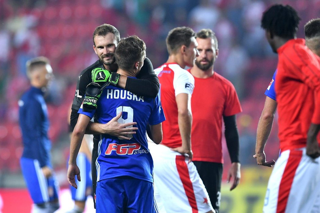 Gólman Slavie Ondřej Kolář utěšuje olomouckého záložníka Davida Housku poté, co v utkání nedal penaltu