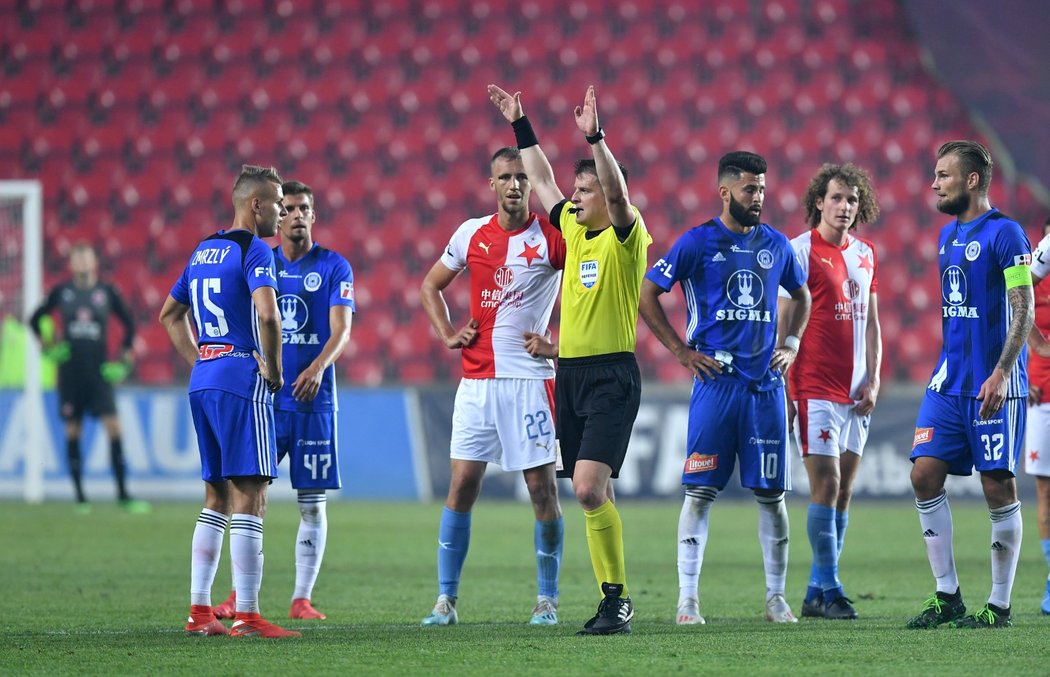 Sudí Zbyněk Proske přerušuje utkání Slavie s Olomoucí ve chvíli, kdy jde k videu zkontrolovat spornou situaci vedoucí k penaltě Olomouce