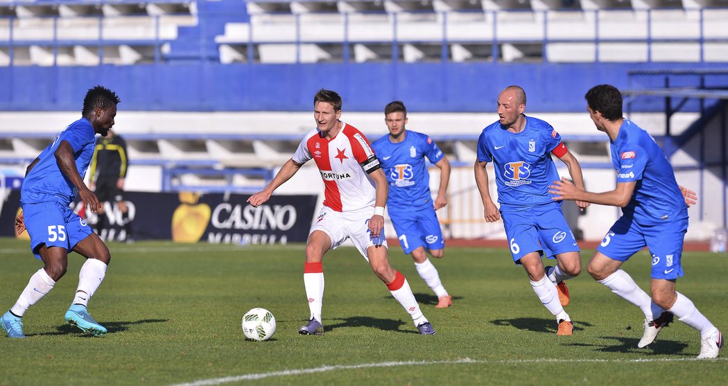 Kanonýr Slavie Milan Škoda v obložení obránců polského týmu Lech Poznaň