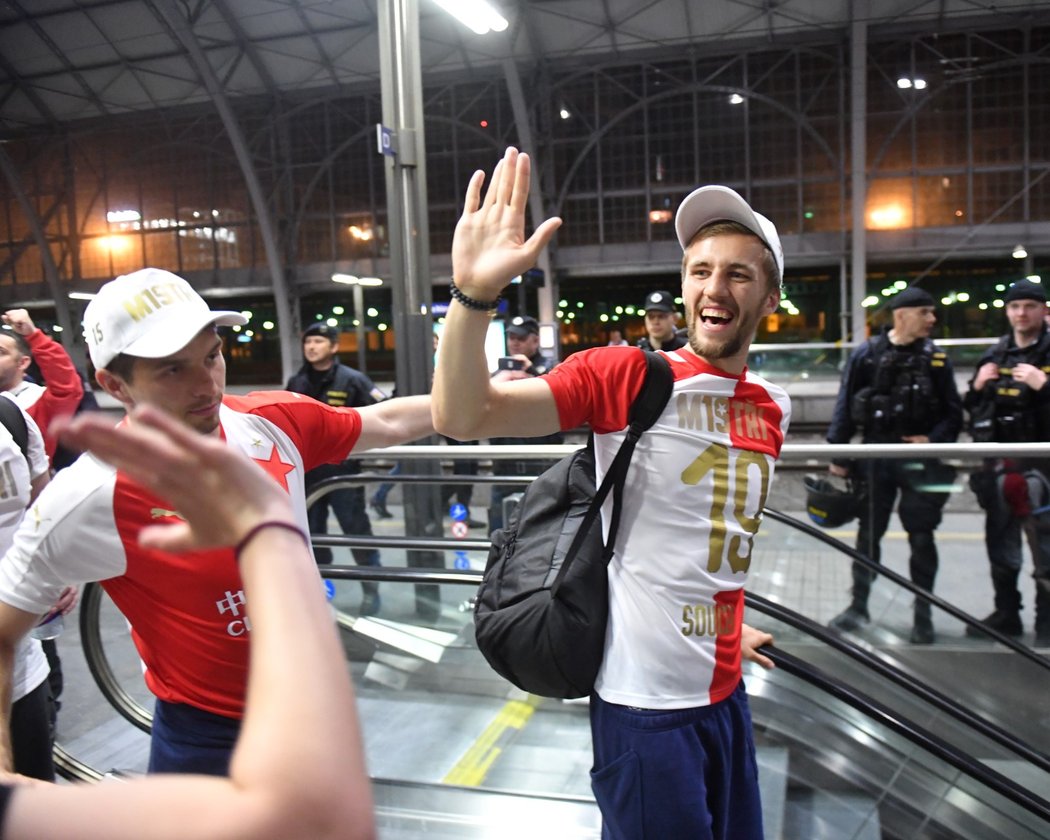 Tomáš Souček zdraví na pražském Hlavním nádraží slávistické fanoušky při oslavách titulu, za ním obránce Ondřej Kúdela