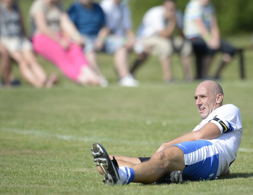 Jan Koller unaveně leží na trávníku v průběhu oslav fotbalu ve Smetanově Lhotě