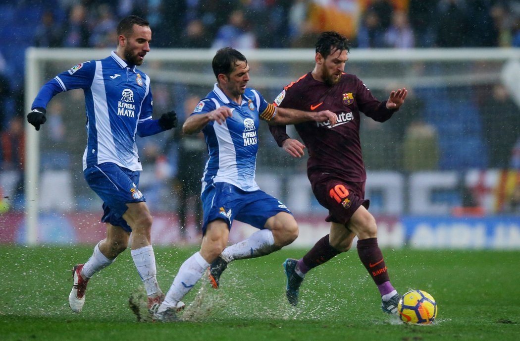 Argentinský kanonýr Lionel Messi se snaží uniknout dvojici soupeřů