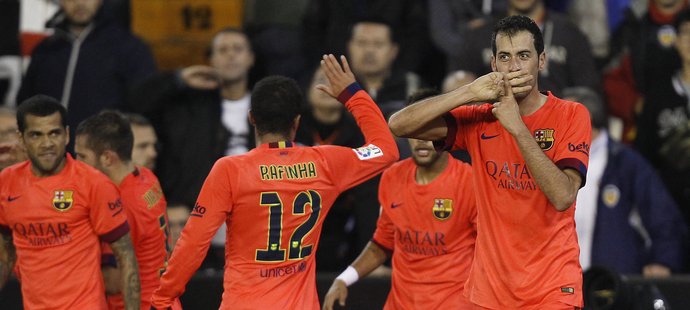 Fotbalisté Barcelony oslavují gól Sergia Busquetse do sítě Valencie.