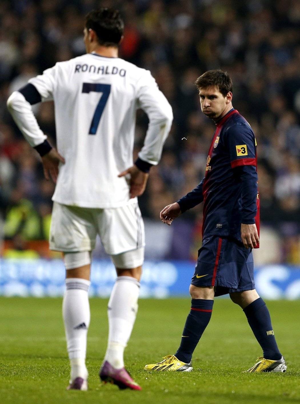 Lionel Messi prochází (a odplivává si) kousek od Cristiana Ronalda v prvním letošním El Clásiku