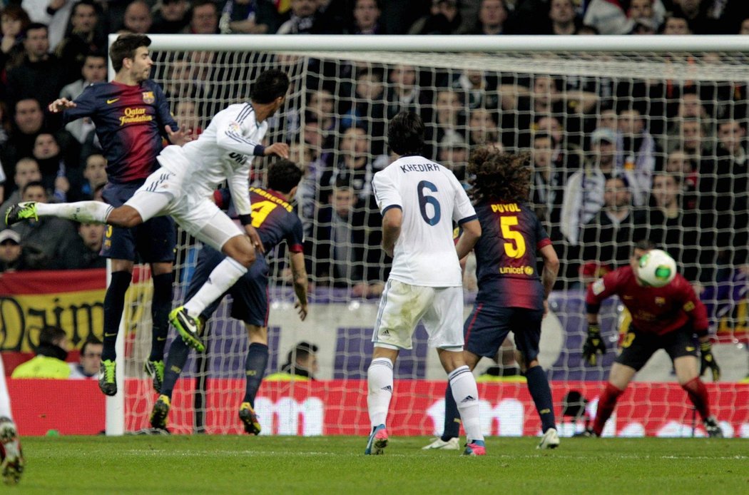 Raphael Varane (druhý zleva) posílá hlavou míč do branky Barcelony