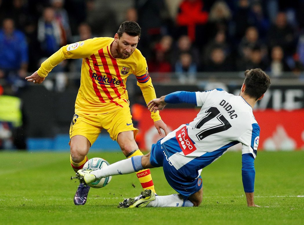 Lionel Messi se snaží přejít přes obránce v utkání Barcelony s Espaňolem