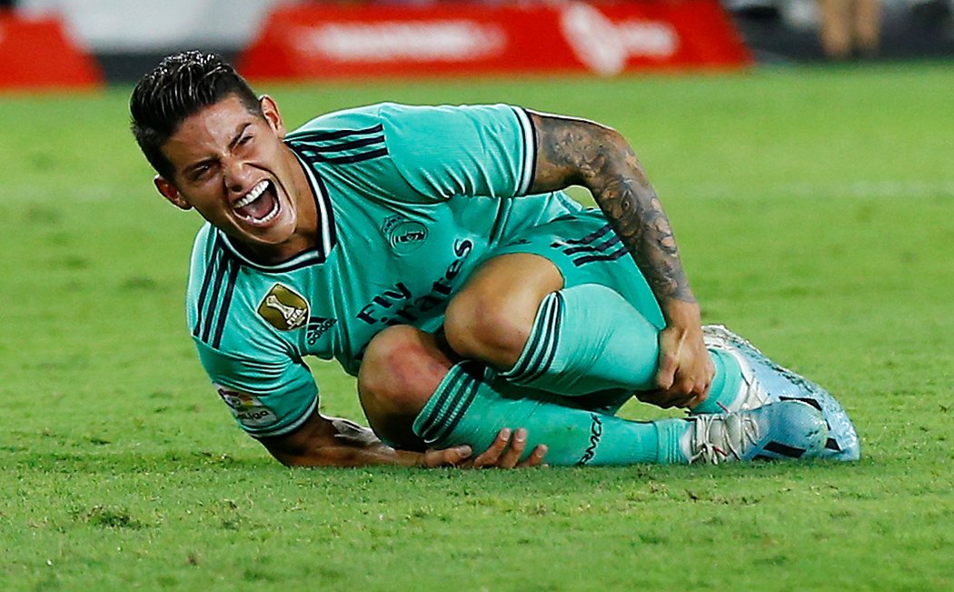 Hvězdný záložník Realu Madrid James Rodríguez se svíjí na zemi po jednom ze zákroků v ligovém duelu se Sevillou