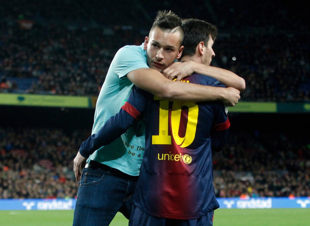 Fanoušek objal Lionela Messiho přímo na trávníku během utkání Barcelony s Atlétikem