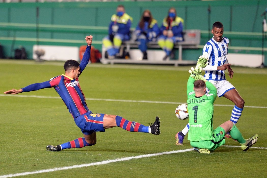 Brankář Barcelony Marc-André ter Stegen zasahuje s Ronaldem Araujem proti útoku Alexandera Isaka ze San Sebastianu