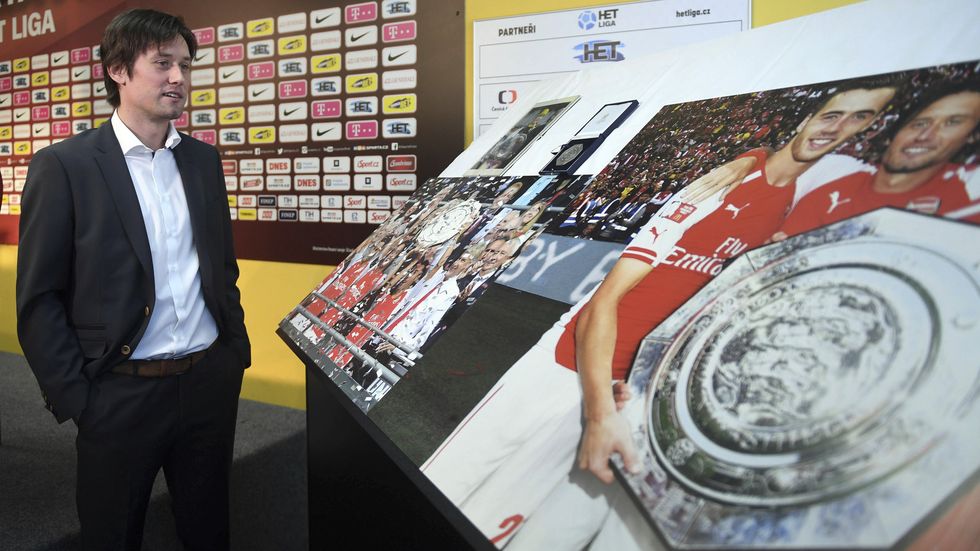 Tomáš Rosický si při své rozlučkové tiskové konferenci prohlíží fotky ohlížející se za jeho kariérou...
