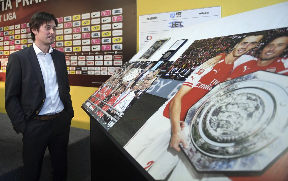 Tomáš Rosický si při své rozlučkové tiskové konferenci prohlíží fotky ohlížející se za jeho kariérou...