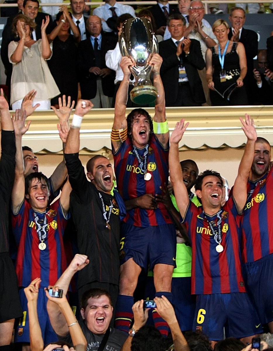 Kapitán Barcelony Carles Puyol s trofejí za vítězství v Superpoháru UEFA nad Šachtarem Doněck